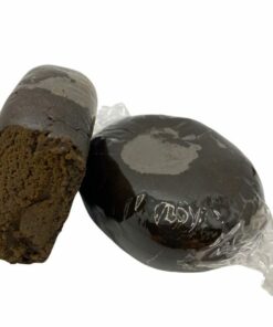 Deux morceaux de résine foncée, l'un emballé sous film plastique, l'autre coupé, révélant une texture moelleuse et dense à l’intérieur.